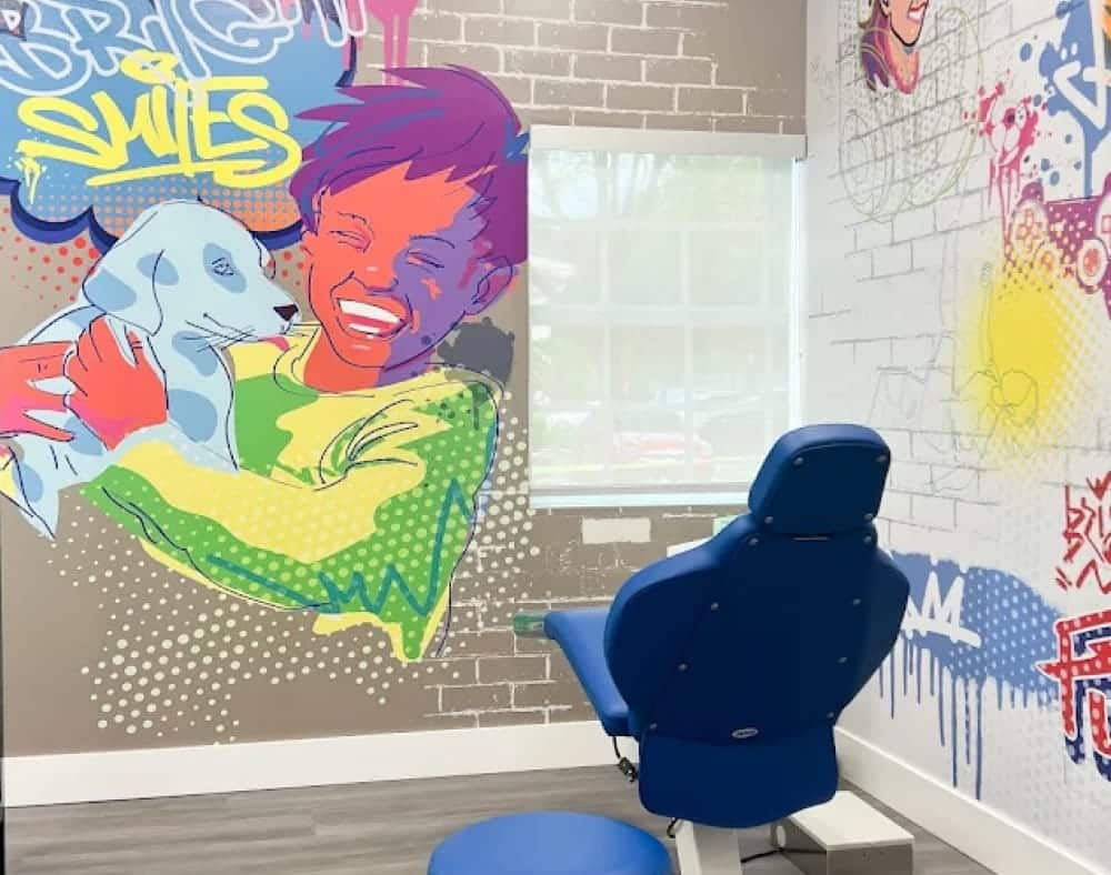 A dental chair in a colorful treatment room with a mural inside the Jacaranda Smiles Plantation office.
