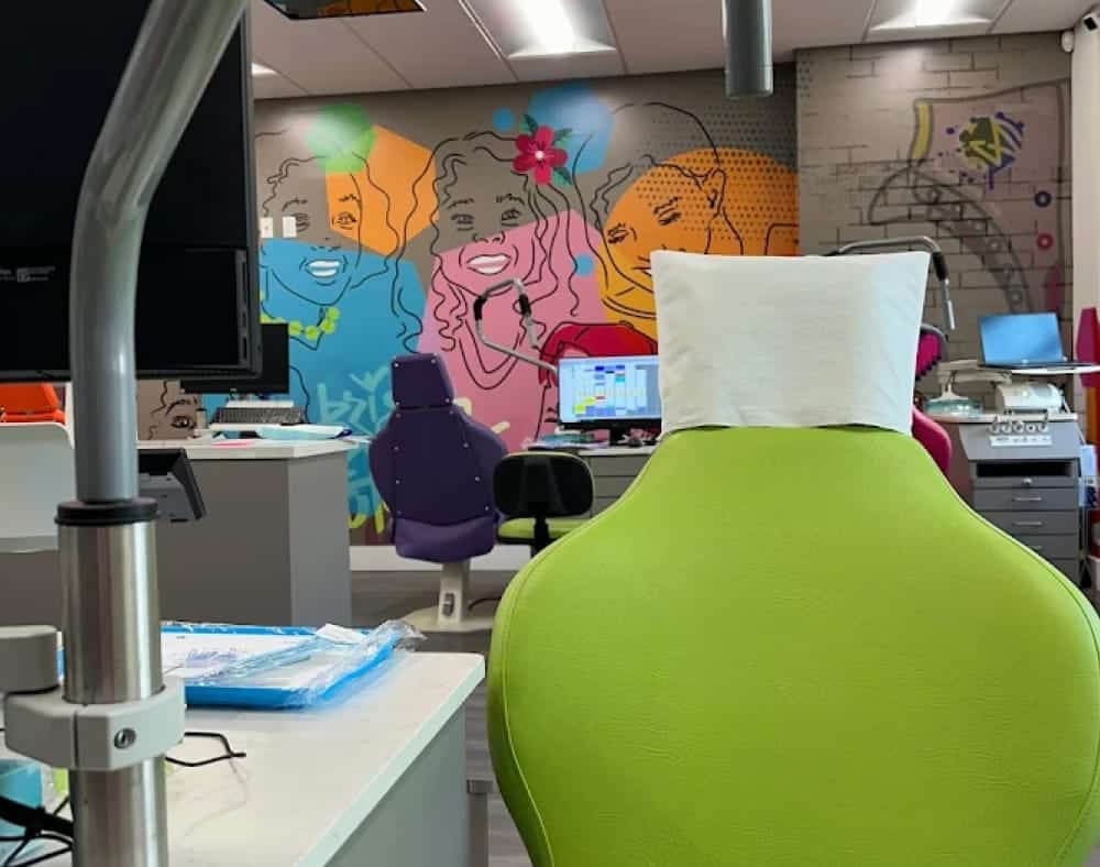 A dental chair and equipment in a colorful treatment area inside the Jacaranda Smiles Plantation office.